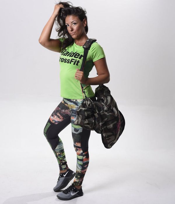 Woman in activewear performing a dynamic cardio movement in a modern studio.